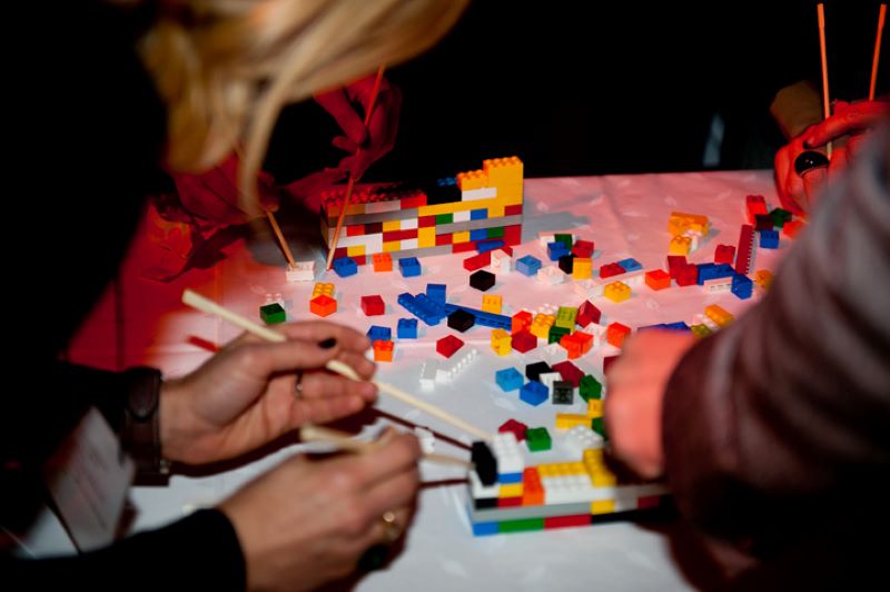 Udeleženci gradijo zid iz lego kock