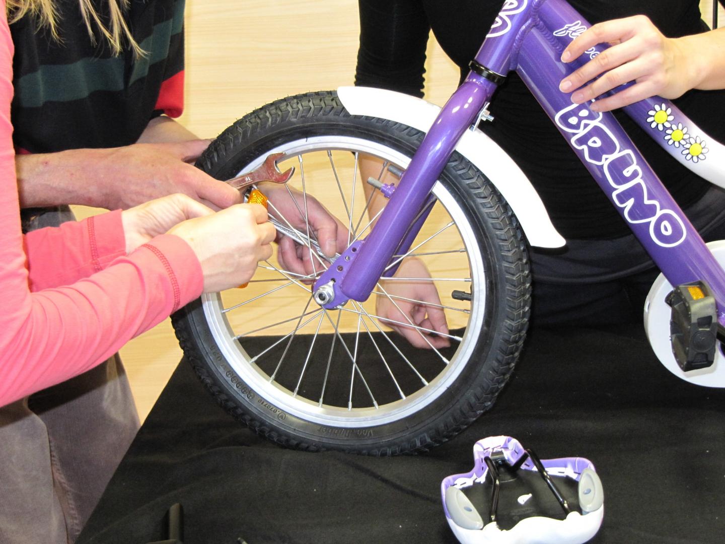Udeleženci sestavljajo kolo na timskem programu Tovarna koles